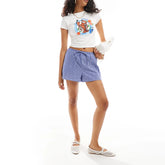 Woman wearing a white t-shirt with a colorful design and blue shorts
